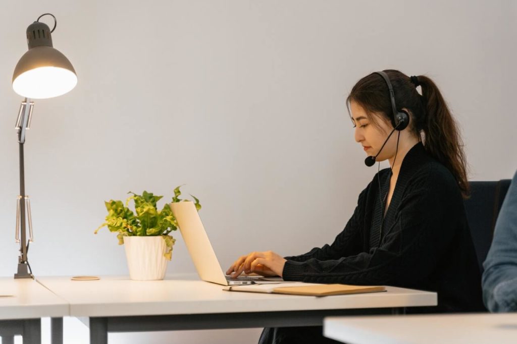 a person wearing a headset and sitting at a desk