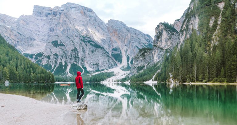 a person standing on a dock in front of a mountain